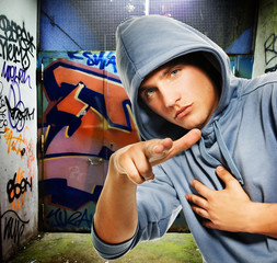 Cool looking hooligan in a graffiti painted gateway