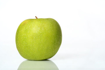 Juicy wet green apple on a table with isolated white background
