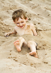 Happy child playing in the sand