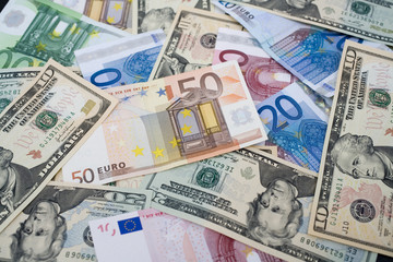 Euro und Dollars liegen bunt gemischt auf einem Tisch