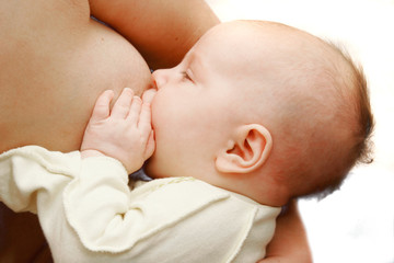baby near breast over white