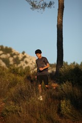 Runner moving through sunlit landscape.