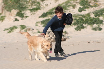 ni&ntilde;o con perro en la playa