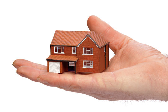Hand holding a miniature house