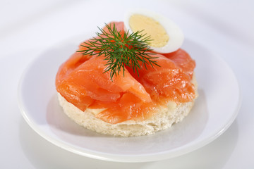 Smoke salmon on bagel with freshly black pepper.