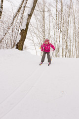 Little girl sliding down hill on ski