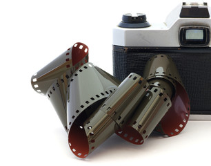 Tangled roll of 35mm film in front of a vintage camera.