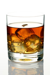 Glass of whiskey on rocks isolated on white