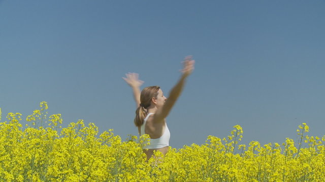 happy woman pivoting in rape field close