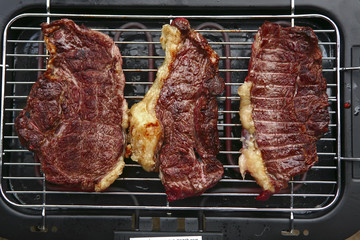three roast steak on electrical brazier