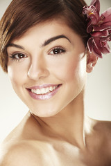 Fototapeta premium Beautiful young woman with orchid flowers