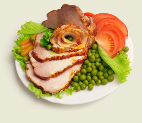 Сold boiled pork with salad, tomato, pea on plate on white