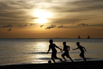 Fototapeta premium Silhouette of Children Playing at the Beach