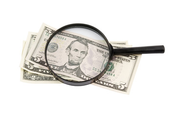 Black magnifying lens and dollars isolated on white
