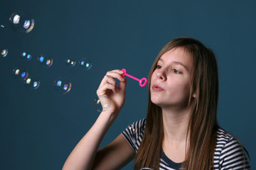 Fototapeta premium profile of a pretty teenage girl blowing bubbles