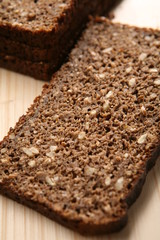 Slices of rye-bread on wood surface.