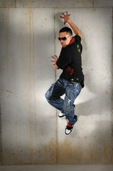 Fototapeta na wymiar Hip Hop Jumping Against the Wall