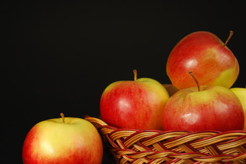apples in a basket on a black background