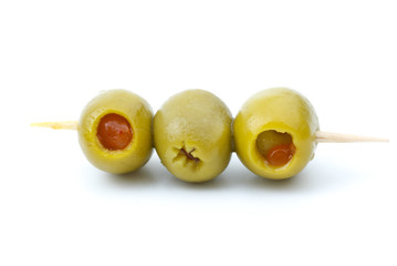 Some olives stuffed with pepper on a wooden toothpick