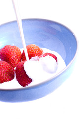 Cream pouring on strawberries