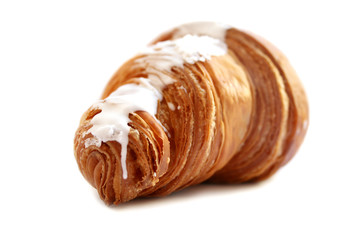 croissant with sugar glaze largely on a white background