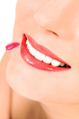 Naklejka premium Putting on lip gloss