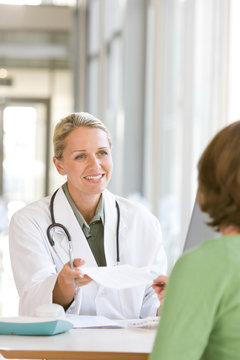 Attractive young caring doctor talking to patient