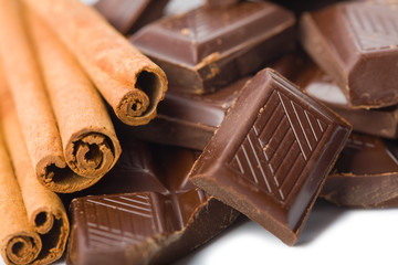 broken pieces of chocolate and cinnamon isolated