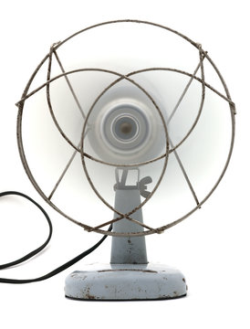 Front view of an old electric fan with the power on.