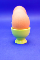 egg in green eggcup  isolated on blue. easter