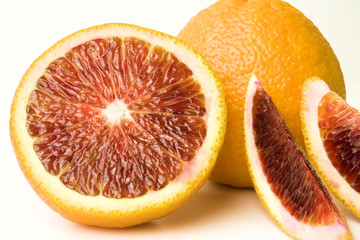 Fresh Whole and sectioned blood oranges close-up