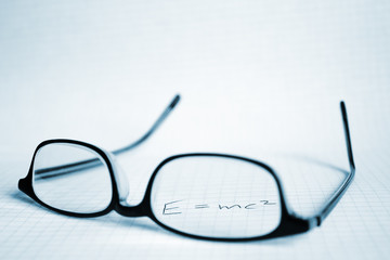 Glasses and paper with Albert Einstein's E mc2 © chehov