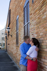 Couple Kissing By Brick Building