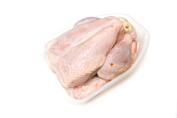 Whole raw chicken on a white studio background.