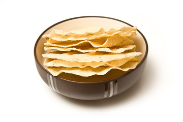 bowl of Pappadoms isolated on a white studio background.
