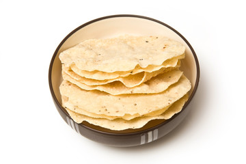 bowl of Pappadoms isolated on a white studio background.