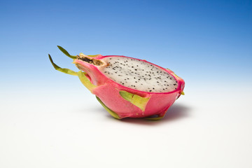 Dragon fruit halved on a graduated blue studio background.