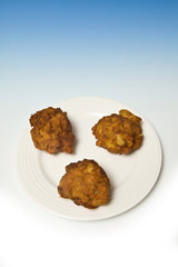 Onion Bhaji's on a blue studio background.