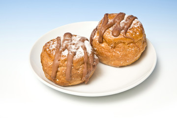 Cream buns on a blue studio background.