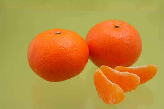 Orange mandarins on green background