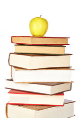 Yellow apple on pile of books