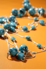 turquoise necklaces over orange background