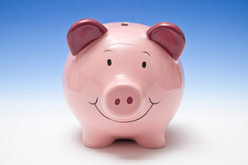 Piggy bank style money box on a blue studio background.