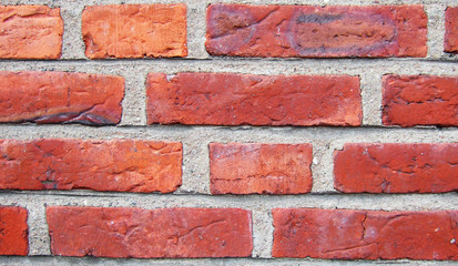 Obraz premium A close up of a red brickwall wtih grey plaster