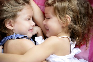 Two twin sisters in a hug, close up