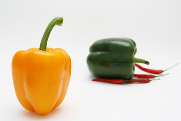 Orange, green and red pepper on white background