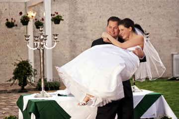 groom lifting bride laughing