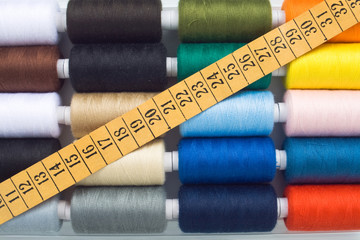 closeup of multicolored sewing spools and meter