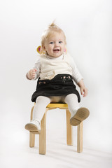 A beautiful smiling baby sitting on the chair