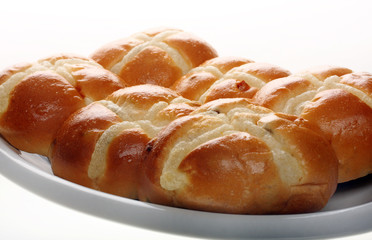 Easter hot cross buns stacked on a flat plate